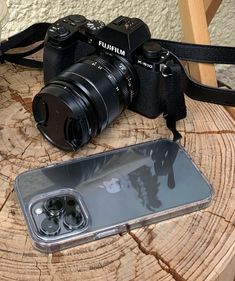 an iphone case sitting on top of a wooden table next to a camera and lens