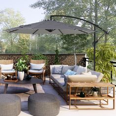 an outdoor living area with couches, tables and umbrellas