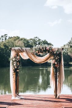 an image of a wedding ceremony setup on the dock with flowers and draping