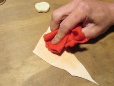 a person is wiping down some paper with a cloth on top of the piece of paper