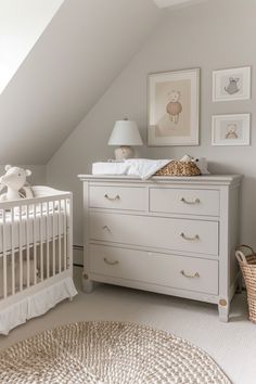 a baby's room with a crib, dresser and pictures on the wall