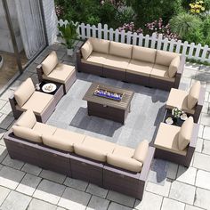 an outdoor living area with couches, tables and a fire pit in the middle