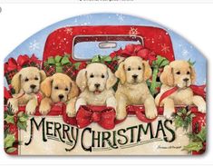 a group of puppies sitting on top of a red truck with merry christmas lettering