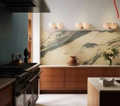 a modern kitchen with marble counter tops and wooden cabinets, along with an island in the middle