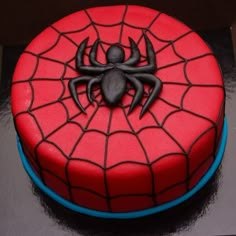 a spiderman cake with red frosting on top