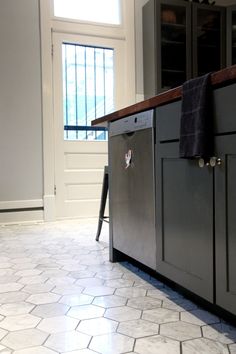 a kitchen with gray cabinets and tile flooring