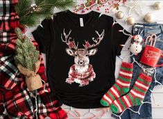 Celebrate the festive season in style with this cozy Christmas shirt featuring an adorable reindeer adorned with antlers decorated with berries and a plaid scarf. Perfect for holiday gatherings, winter lounging, or gifting to loved ones, this shirt adds a touch of warmth and cheer to your wardrobe. Soft and comfortable, it's the ideal choice for embracing the holiday spirit! 👕 HOW TO ORDER: * Choose your t-shirt color * Choose your size * Choose your design&text color * PLEASE make sure all you Christmas Shirts With Deer, Plus Size Christmas, Shirts Plus Size, Deer Christmas, Christmas T Shirts, Design Text, Oh Deer, Customise T Shirt, Christmas Deer