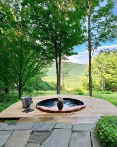 a hot tub sitting on top of a wooden platform in the middle of a forest