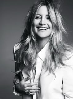 a black and white photo of a woman with long blonde hair smiling at the camera