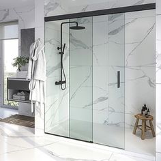 a bathroom with marble walls and flooring next to a bathtub, shower stall and sink