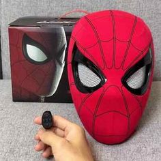 a person holding a remote control in front of a spider - man mask