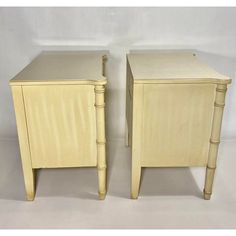 a pair of nightstands made out of wood and painted in light yellow with bamboo handles