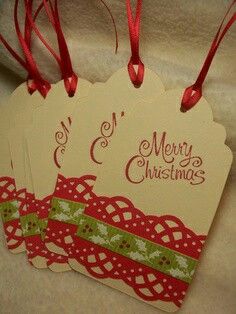 two tags with merry christmas written on them are hanging from red ribboned stringes