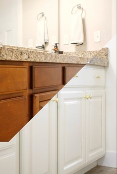 a bathroom with white cabinets and marble counter tops