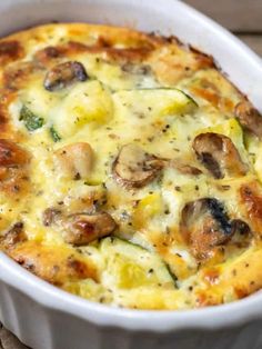 a casserole dish with mushrooms, cheese and broccoli in it on a wooden table