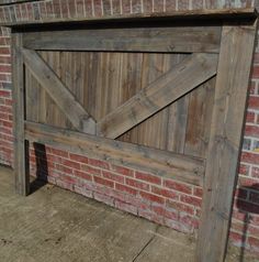 a close up of a wooden gate near a brick wall