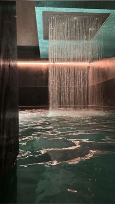 a shower head in the middle of a pool with water flowing from it's sides