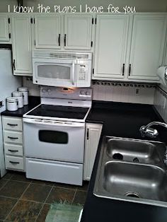 a white stove top oven sitting inside of a kitchen next to a sink and refrigerator