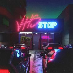 two cars parked in front of a neon sign