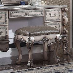 an ornate desk and chair are shown in this image, with a mirror on the wall behind it