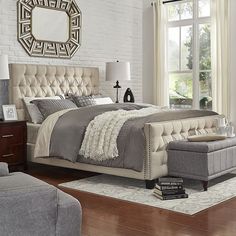 a bedroom with a bed, chair and ottoman