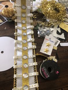 a table topped with lots of gold and white items on top of a wooden table