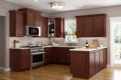 a kitchen with brown cabinets and white counter tops, wood flooring and stainless steel appliances