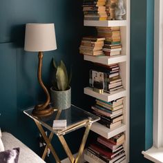 a room with bookshelves and a lamp on the table in front of it