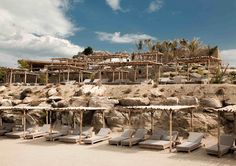 there are many lounge chairs on the beach