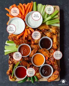 chicken wings with dipping sauces and carrots on a cutting board next to celery