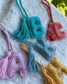 four crocheted purses with tasselled handles on top of a blanket