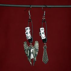 the earrings are made with silver letters and an angel on each earring that says, dad