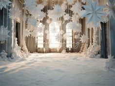 snowflakes hanging from the ceiling in front of a window with curtains and windowsills