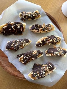 chocolate covered donuts are sitting on a paper towel with nuts and other toppings