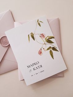 two wedding cards with flowers on them are laying next to an envelope and wax stamp