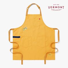 a yellow apron with patches on it and the words vermont creamery written in red