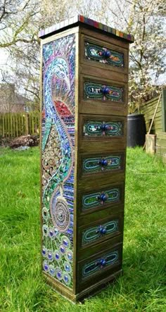 a tall wooden cabinet sitting in the grass