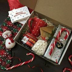 a box filled with lots of different types of christmas gifts and candy canes on the floor