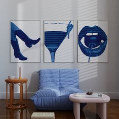 three paintings hang on the wall above a blue couch in a room with wooden floors