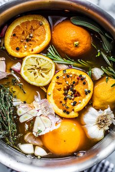 a pot filled with oranges and herbs