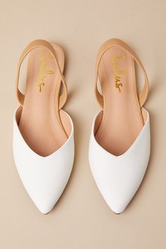 a pair of white shoes sitting on top of a beige floor next to each other