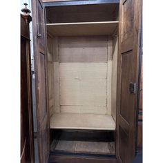 an empty wooden closet with the door open