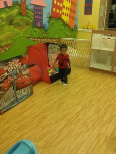 a young boy is playing with his toys in the playroom