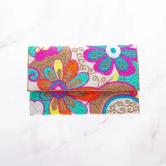 a colorful wallet sitting on top of a white table next to a marble countertop