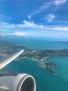 an airplane wing flying over the ocean and land