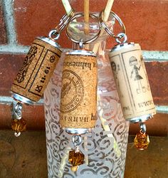 three wine corks in a glass bottle on a brick wall with some beads hanging from it