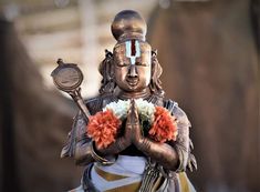 a buddha statue with flowers in its hands