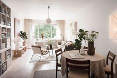 a living room filled with lots of furniture and bookshelves next to a window