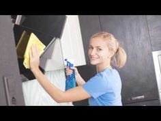 a woman is cleaning the kitchen cabinets with a sponge and detergent on her hand