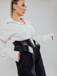 The model is wearing a size XL and is 33.5"/85 cm waist, 35"/89 cm underbust.Stand out from the crowd with this stunning Wasp Corset Belt. Its versatile design allows you to wear the buckles facing back or front, creating a bold and edgy look that's perfect for any occasion. The Wasp design hugs your torso to sculpt a dramatic hourglass waistline. Wasp Waist Corset, Modern Fitted Corset Belt With Belt Loops, Edgy Black Underbust Corset Belt, Corset Harness, Black Leather Corset Belt With Belt Loops, Fitted Leather Corset Belt, Wasp Waist, Corset Belts, Harness Belt